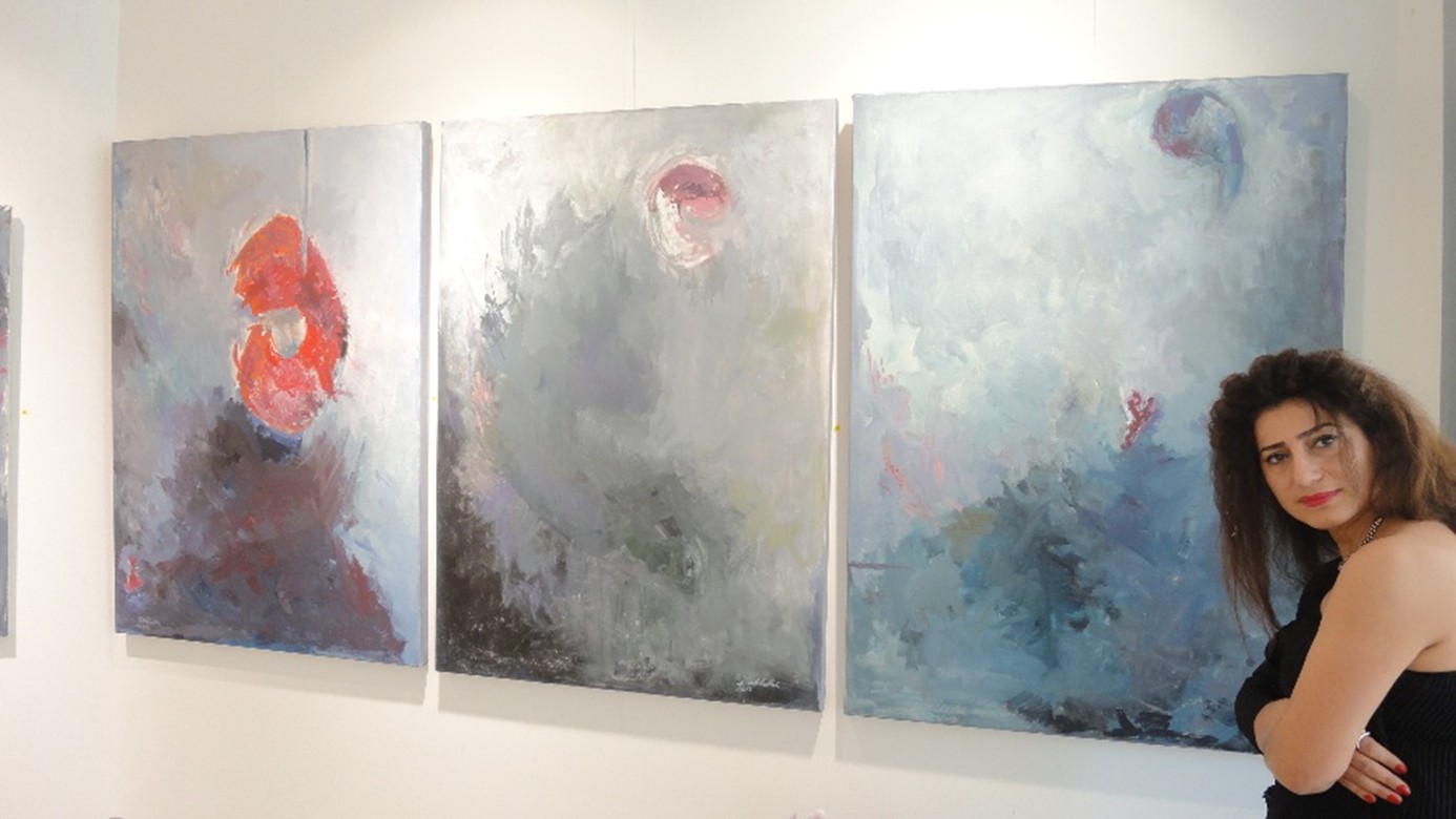 Sibel Akkulak-Dosch am rechten Bildrand im Anschnitt präsentiert drei Ihrer Malereien aus Acryl